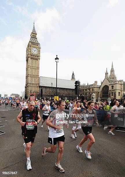 Participants run through Parliament Square in Westminster during the 2010 Virgin London Marathon on April 25, 2010 in London, England.