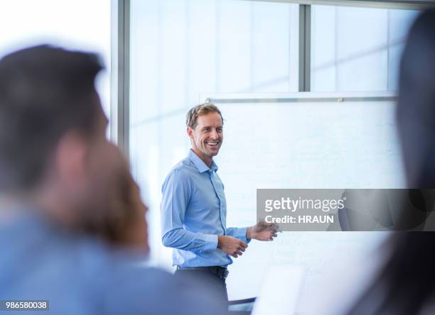 businessman giving presentation to colleagues - differential focus stock pictures, royalty-free photos & images