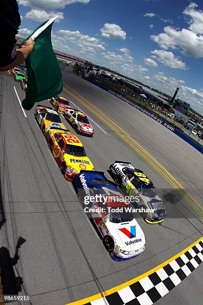 Jimmie Johnson, driver of the Lowe's Chevrolet, and Matt Kenseth, driver of the Valvoline Ford, lead the field to the green flag to start the the...