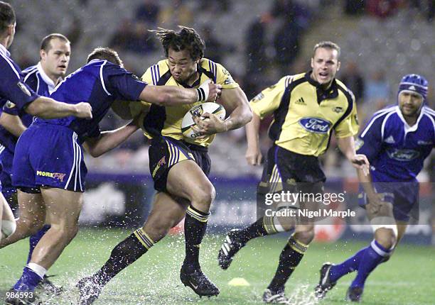 Tana Umaga of the Hurricanes is tackled by Xavier Rush of the Blues during the Super 12 match between the Blues and the Hurricanes at Eden Park,...