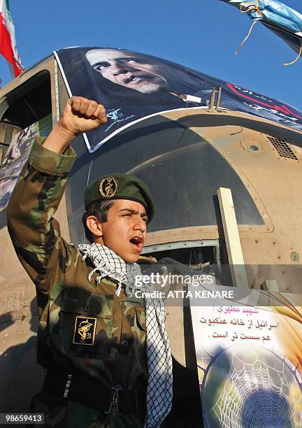 Young member of Iran's Basij volunteer Islamist militia shouts a slogan as he stands next to the wreckage of a captured US air force CH-53 Sea...