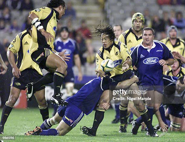 Tana Umaga of the Hurricanes is tackled by Xavier Rush of the Blues during the Super 12 match between the Blues and the Hurricanes at Eden Park,...