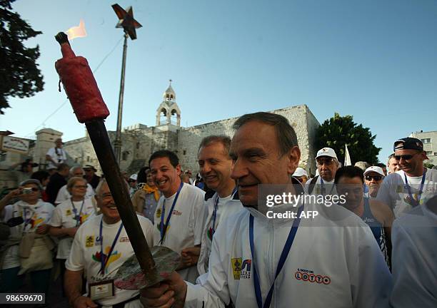 An Italian peace activist holds a torch that received the blessing of Pope Benedict XVI in front of the Church of the Nativity in Bethlehem on April...