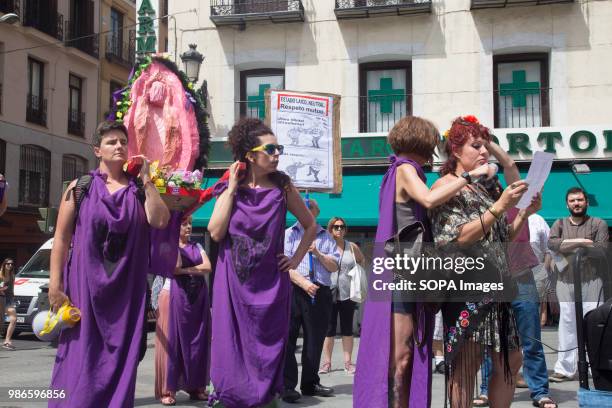 Feminist activists with the cardboard figure of a Vagina rebellious while reading the press release during the press conference. The judge of Seville...