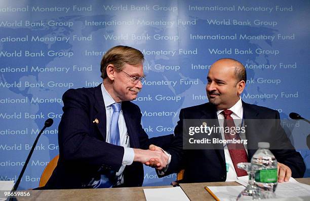 Robert Zoellick, president of the World Bank, left, shakes hands with Sheikh Mohammed Bin Essa Al-Khalifa, chief executive officer of the Bahrain...