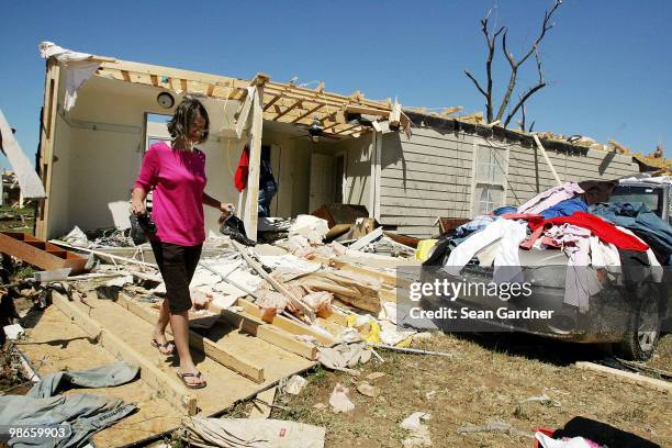 Morgan Hayden, carries out a pair of shoes from her home on April 25, 2010 in Yazoo City, Mississippi. On Saturday a massive tornado hit the...