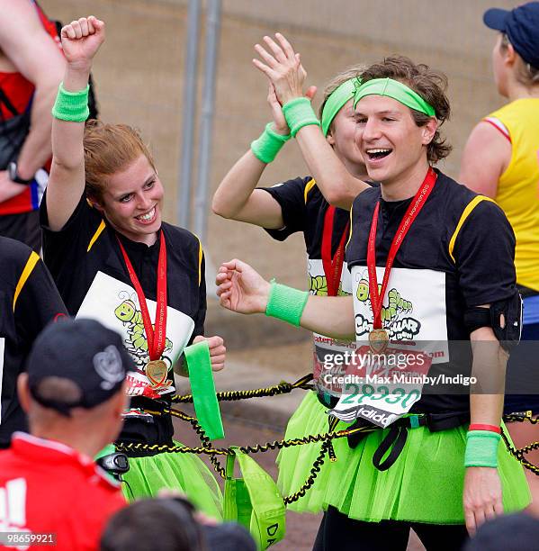 Princess Beatrice of York punches the air as she and boyfriend Dave Clark complete the Virgin London Marathon as part of the 'Caterpillar Run' Team,...