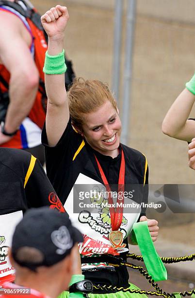 Princess Beatrice of York punches the air as she completes the Virgin London Marathon as part of the 'Caterpillar Run' Team, consisting of 32 runners...