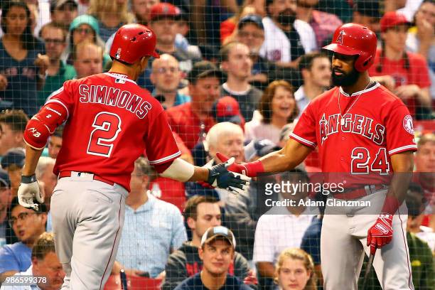 Andrelton Simmons high fives Chris Young of the Los Angeles Angels after hitting a solo home run in the fourth inning of a game against the Boston...