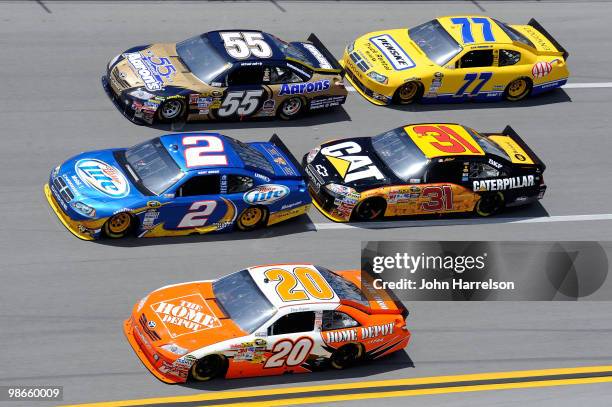 Kurt Busch, driver of the Miller Lite Dodge, races Joey Logano, driver of the Home Depot Toyota, and Michael Waltrip, driver of the Aaron's 55th...