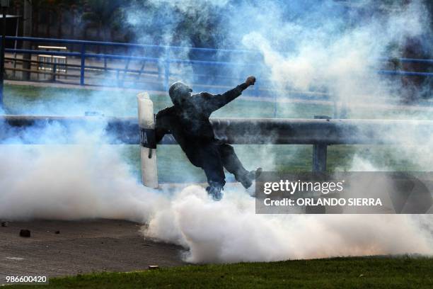 Riot policeman fires tear gas to supporters of Honduran opposition leader Manuel Zelaya -- a former president ousted by the military -- as they...