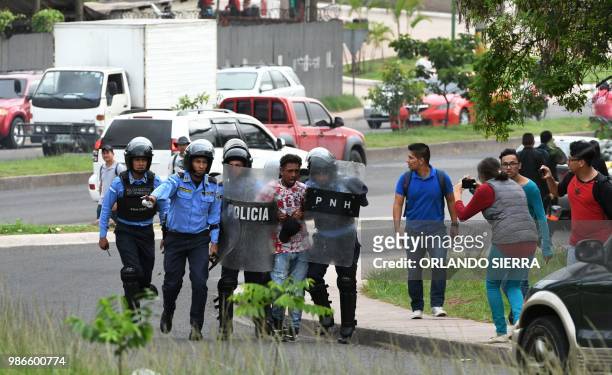 Riot policemen fires arrest a supporter of Honduran opposition leader Manuel Zelaya -- a former president ousted by the military -- during a protest...