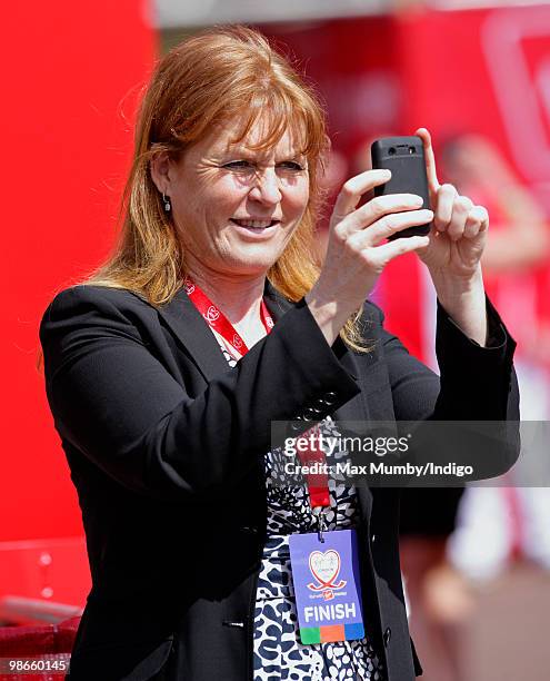 Sarah Ferguson, The Duchess of York takes photographs of runners as she waits for daughter HRH Princess Beatrice of York to complete the Virgin...