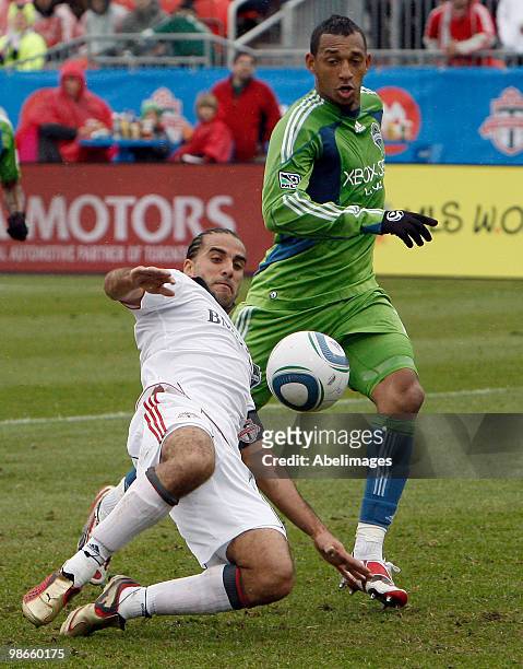 Dwayne De Rosario of Toronto FC kicks the ball past Tyrone Marshall of the Seattle Sounders FC during a MLS game at BMO Field April 25, 2010 in...