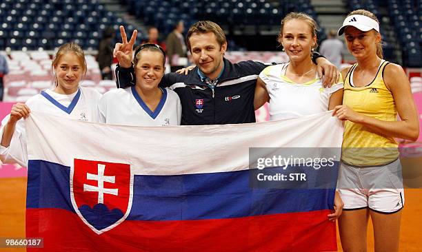 Daniela Hantuchova, coach Matej Liptak, Magdalena Rybarikova, Lenka Wienrova, Jana Cepelova of Slovakia hold a national flag to celebrate after...