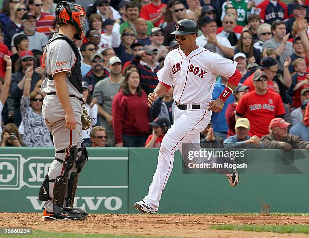 Victor Martinez scores a run in the sixth inning by the catcher Craig Tatum of the Baltimore Orioles at Fenway Park on April 25, 2010 in Boston,...