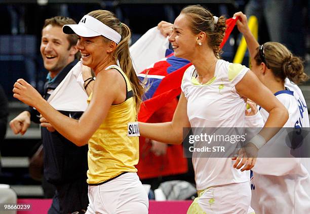 Magdalena Rybarikova, Daniela Hantuchova and coach Matej Liptak of Slovakia hold a national flag to celebrate after winning the Fed cup World Group...