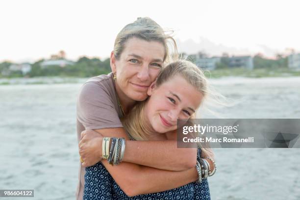 mother and daughter embracing at the beach - saint simons island stock-fotos und bilder
