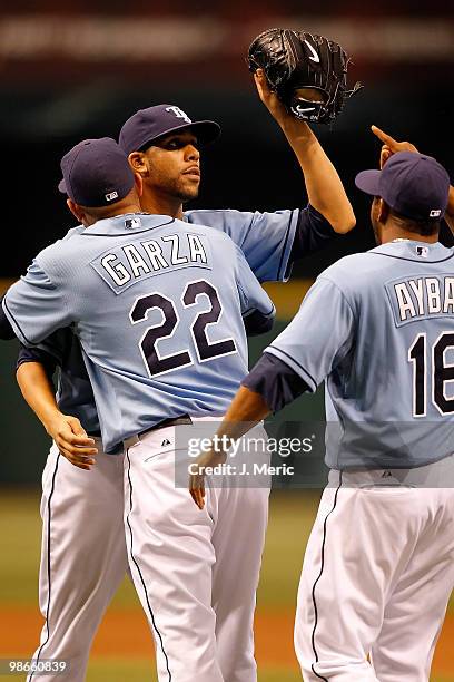 Pitcher David Price is congratulated by pitcher Matt Garza and infielder Willy Aybar of the Tampa Bay Rays after his complete game shutout against...