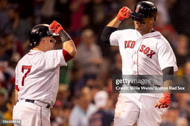 Rafael Devers of the Boston Red Sox reacts with Christian Vazquez after hitting a solo home run during the fifth inning of a game against the Los...