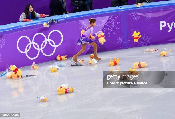 Dpatop - Little ice skater gathers plush toys that were thrown onto the ice by fans of Japanese ice skater Hanyu during the men's single skating...