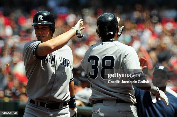 Mark Teixeira and Marcus Thames of the New York Yankees celebrate a run against the Los Angeles Angels of Aneheim on April 25, 2010 in Anaheim,...