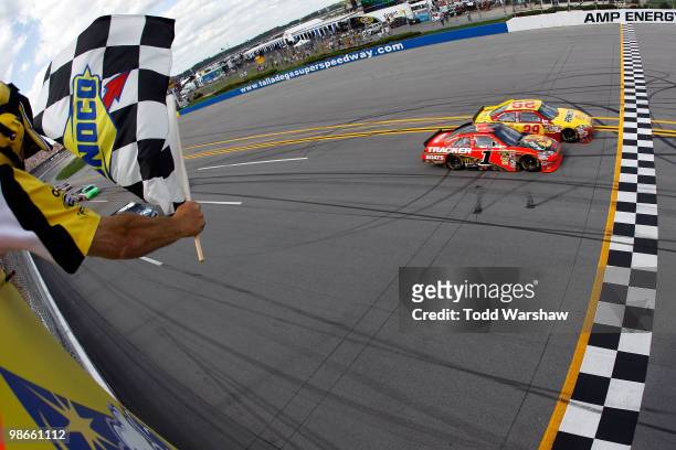 Kevin Harvick, driver of the Shell/Pennzoil Chevrolet, crosses the finish line ahead of Jamie McMurray, driver of the Bass Pro Shops Chevrolet, to...