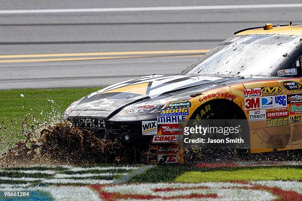 Jeff Burton drives the Caterpillar Chevrolet, through the front stretch grass after suffering damage during multicar incident in the NASCAR Sprint...