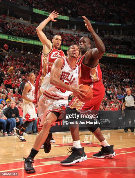 Joakim Noah of the Chicago Bulls drives to the basket past Anthony Parker and Shaquille O'Neal of the Cleveland Cavaliers in Game Four of the Eastern...