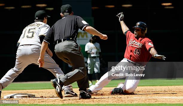 Carlos Lee of the Houston Astros slides into third base for a triple as third baseman Andy LaRoche of the Pittsburgh Pirates can't handle the throw...