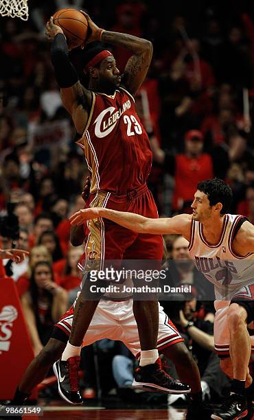 LeBron James of the Cleveland Cavaliers leaps to pass over Kirk Hinrich of the Chicago Bulls after pulling down a rebound in Game Four of the Eastern...