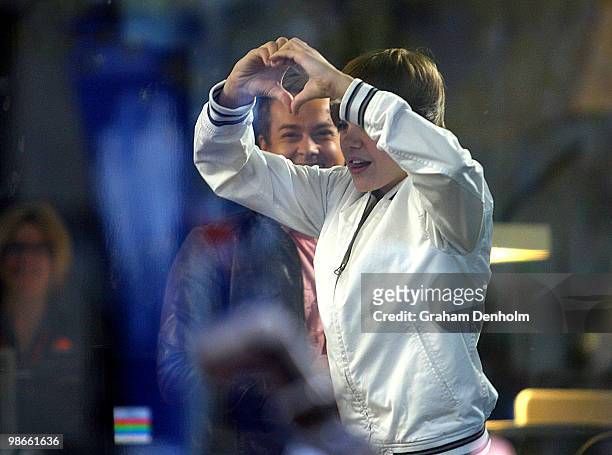 Canadian pop star Justin Bieber gestures to fans whilst making a brief appearance during the "Sunrise" broadcast at Martin Place on April 26, 2010 in...