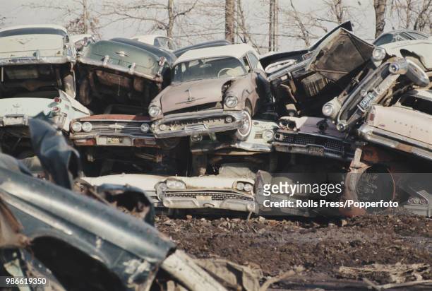 View of dumped, wrecked and abandoned cars piled on top of each other on a scrap heap of American automobiles in Detroit, Michigan in 1969.
