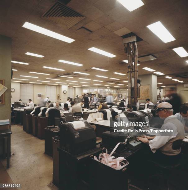 View of employees, journalists, copy editors and clerks working in the news room at the United Press International news agency office in New York in...