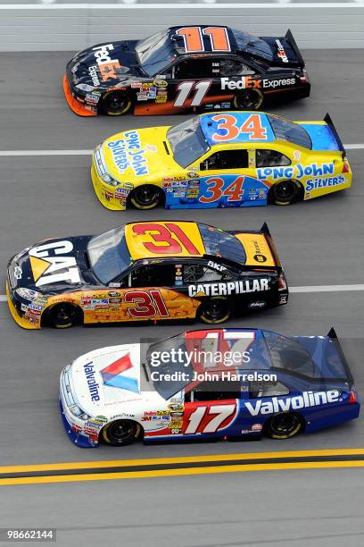 Denny Hamlin, driver of the FedEx Express Toyota, races Travis Kvapil, driver of the Long John Silver's Ford, Jeff Burton, driver of the Caterpillar...