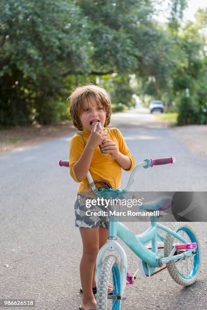 4 year old boy holding bike and popsicle - marc romanelli stock pictures, royalty-free photos & images