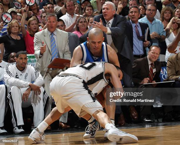 Guard Manu Ginobili of the San Antonio Spurs is tied up with Jason Kidd of the Dallas Mavericks as Gregg Popovich calls the timeout in Game Four of...