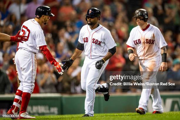 Jackie Bradley Jr. #19 of the Boston Red Sox high fives Mookie Betts and Christian Vazquez after hitting a two run home run during the seventh inning...