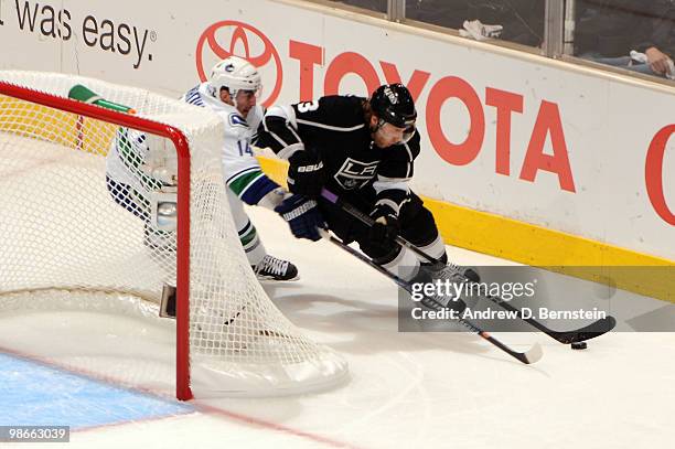 Jack Johnson of the Los Angeles Kings skates with the puck against Alexandre Burrows of the Vancouver Canucks in Game Six of the Western Conference...