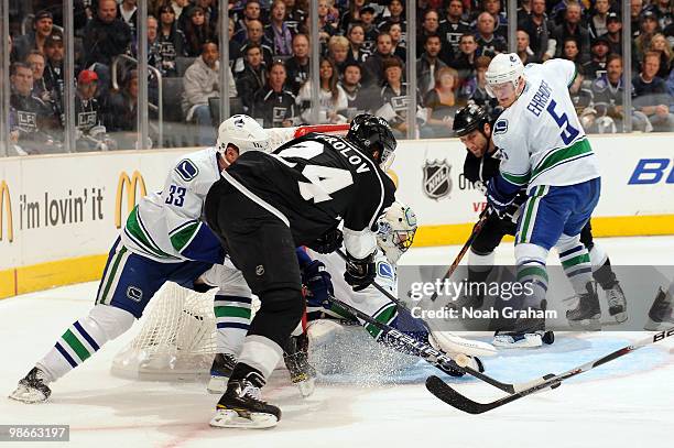 Alexander Frolov of the Los Angeles Kings drives to the net and scores a goal against Roberto Luongo and Henrik Sedin of the Vancouver Canucks in...