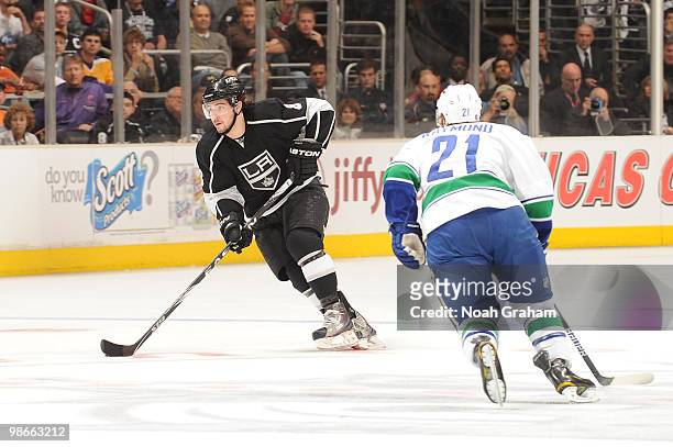Drew Doughty of the Los Angeles Kings skates with the puck against Mason Raymond of the Vancouver Canucks in Game Six of the Western Conference...