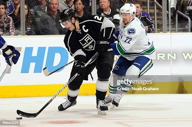 Dustin Brown of the Los Angeles Kings skates with the puck against Daniel Sedin of the Vancouver Canucks in Game Six of the Western Conference...