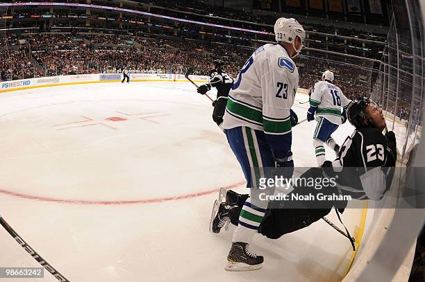 Dustin Brown of the Los Angeles Kings is checked into the boards by Alexander Edler of the Vancouver Canucks in Game Six of the Western Conference...