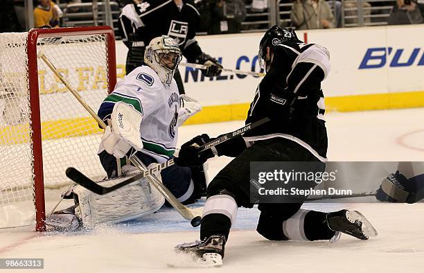 Dustin Brown of the Los Angeles Kings tries to shoot as goaltender Roberto Luongo of the Vancouver Canucks blocks the puck during Game Six of the...