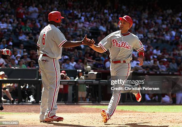 Raul Ibanez of the Philadelphia Phillies high-fives teammate Ryan Howard after they scored runs against the Arizona Diamondbacks during the sixth...