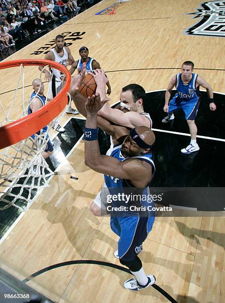 Manu Ginobili of the San Antonio Spurs battles for a rebound with Erick Dampier of the Dallas Mavericks in Game Four of the Western Conference...