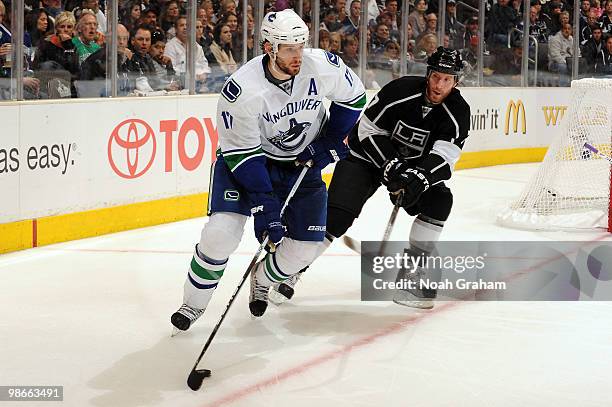 Ryan Kesler of the Vancouver Canucks skates with the puck against Rob Scuderi of the Los Angeles Kings in Game Six of the Western Conference...
