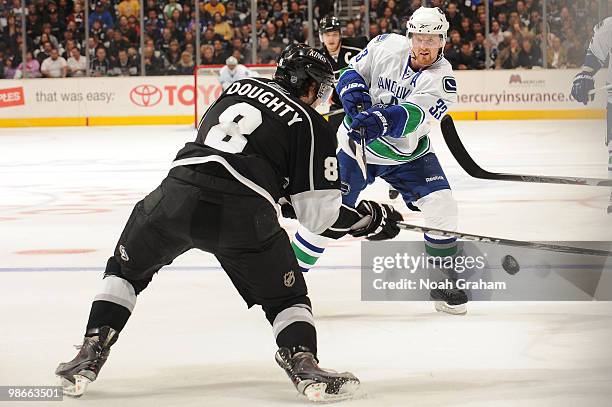 Henrik Sedin of the Vancouver Canucks passes the puck against Drew Doughty of the Los Angeles Kings in Game Six of the Western Conference...