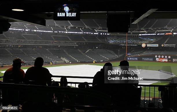 Fans wait out a rain delay during the sixth inning of the game between the New York Mets and the Atlanta Braves on April 25, 2010 at Citi Field in...