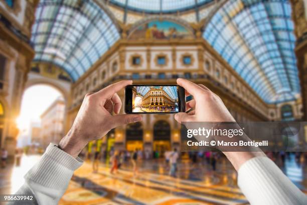 tourist taking a picture at the milan galleria. personal perspective view. - marco bottigelli stock pictures, royalty-free photos & images